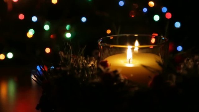 A lighted candle on a Christmas night against the backdrop of a bokeh