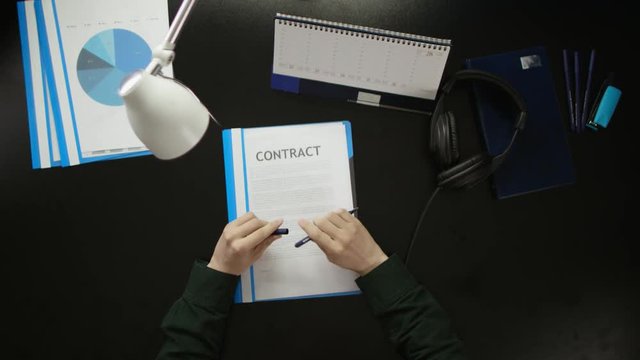 A man is sitting at an office desk and using a phone.