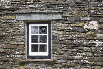 Close up of a window pane on a 15th century building with rustic stone walls