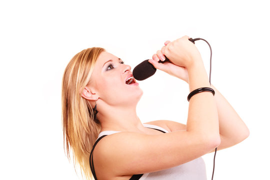 Blonde woman singing to microphone, profile view