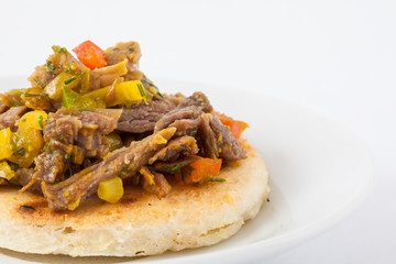 Traditional Colombian arepa topped with shredded beef