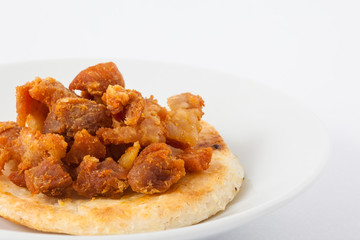 Traditional Colombian arepa topped with pork rind