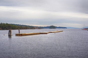 View of floating deck in Oyster Bay, town of Ladysmith, BC, with the Canadian Rockies in the background