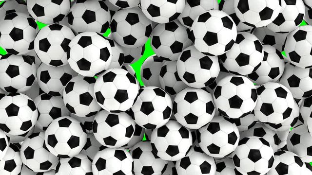 Animated simple soccer balls with plain white and black material falling and tumbling filling up container against green background. Top camera view.