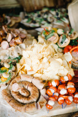 decorated catering banquet table with chips, cheese and different food