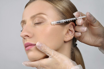Woman receives cosmetic injection anti-aging treatment