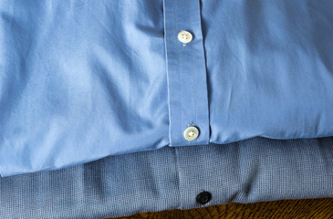 Two blue business shirts folded.