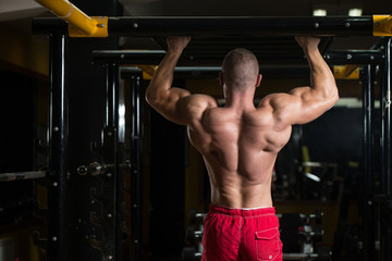 Obraz na płótnie Canvas Bodybuilder Doing Pull Ups Best Back Exercises