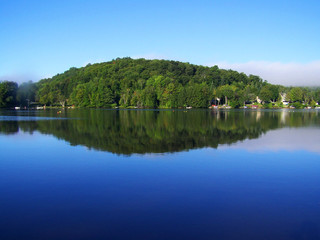 Obraz premium Perfect picture of a blue sky, calm water reflecting the sky and the trees