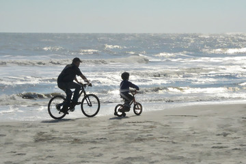 Fototapeta premium father and son bike ride on beach