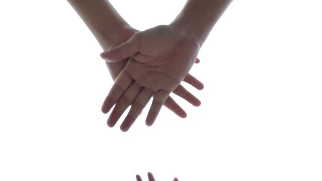 Successful team: many hands holding together on sky background in slowmotion
