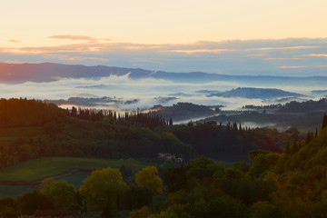 Naklejka premium A foggy September morning in the vicinity of the city of San Gimignano. Tuscany, Italy