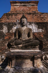 Ancient sitting Buddha statue with clear sky in Sukhothai Historical Park,Thailand