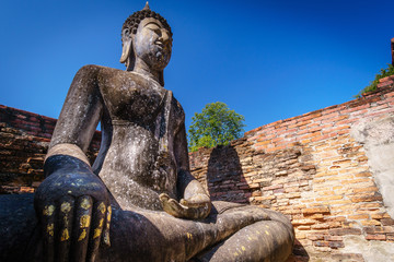 Ancient sitting Buddha statue with clear sky in Sukhothai Historical Park,Thailand