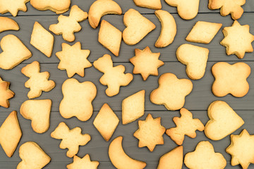 Christmas cookies on gray wooden background. Snowflake, star, man, angel, candy shapes.