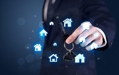 Businessman holding keys with houses around