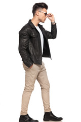 man holding sunglasses is walking