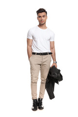 serious young man standing with jacket in his hand