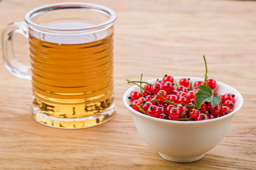glass of tea with red currant/glass of tea and red currant. selective focus