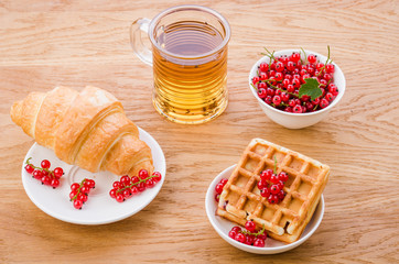 wafers, croissant with red berries and a glass of tea/wafers, croissant with red berries and a glass of tea. Top view