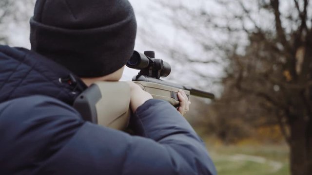 Hunter with gun on forest