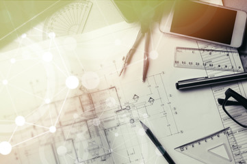 Table top view of Engineers table at office workplace.selective focus.Man hand point to blueprint.Black and white effect.