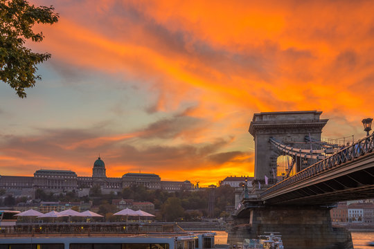 Budapest, Hungary - Beautiful dramatic golden sunset at Szechenyi Chain Bridge with Buda Castle Royal Palace at background