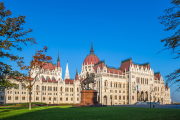 Naklejka premium Budapest, Hungary - The Hungarian Parliament at early in the morning with the horse statue of Ferenc Rakoczi. Clear blue sky