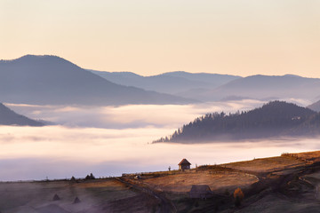 Mała chata na przełęcz w jesień mglisty poranek - 180414630