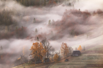 Górska wioska w chmurach mgła i dym w jesień ranku - 180414643