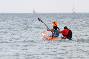 Couple (man and woman) paddling kayak in sea