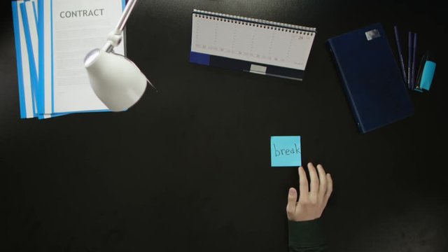 A man is sitting at an office desk and using a phone.
