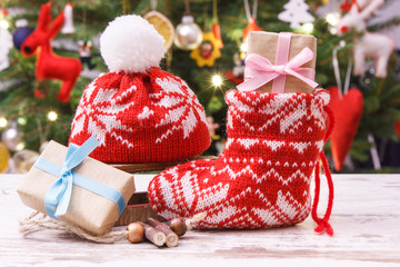 Gift for Christmas with red sock and cap, christmas tree with decoration, festive time concept