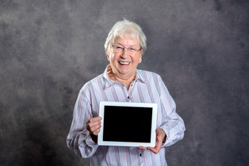 friendly gray hairy elderly woman showing tablet pc