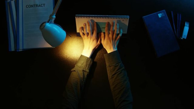 A man is sitting at an office desk and using a phone.