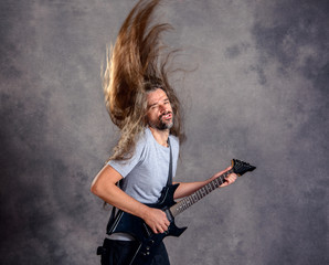 Fototapeta premium wild musician with black guitar and flying hair