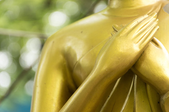 Closeup hands of buddha statue touching the heart on chest
