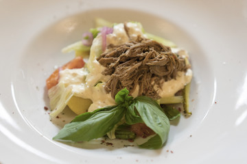 Vegetable salad with veal in a white plate