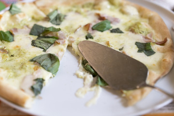 pizza on a white plate with a scapula