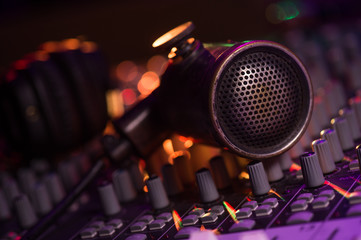 Obraz na płótnie Canvas Vintage Microphone and Headphones on dirty sound mixer panel