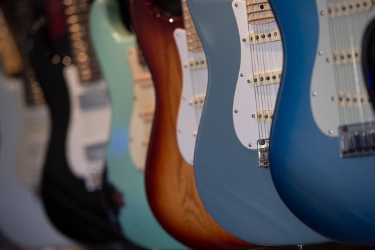 Many Electric Guitars Hanging On Wall In The Shop