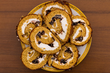 Slices of cake with prunes on a plate on wooden table