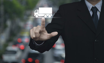 Businessman pressing truck flat icon over blur of rush hour with cars and road, Business transportation service concept