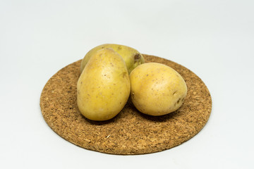two patato isolated on cork with white background