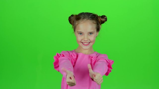 Child shows thumbs up. Green screen