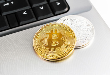 Two bitcoin coins on laptop. Close up.