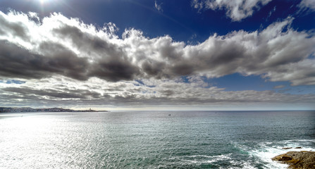 Panoramic view of the entrance of the bay of La Coruna on the coast of Galicia (Spain). Sky with clouds with reflections and sun facing