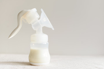 Breast pump with milk for baby over blurred background - 180422441
