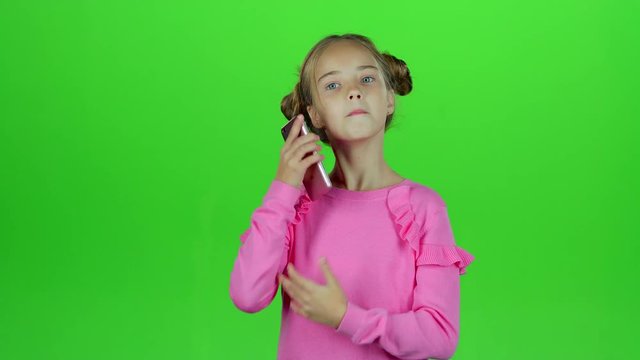 Baby is talking on the phone with her mom. Green screen