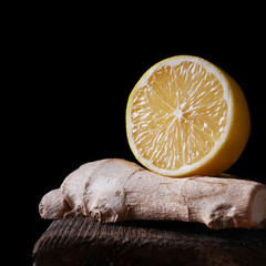 Lemon in a cut and ginger on a dark background.